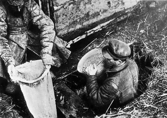 Image -- Soviet officials confiscate grain from a peasant household in Ukraine (early 1930s).