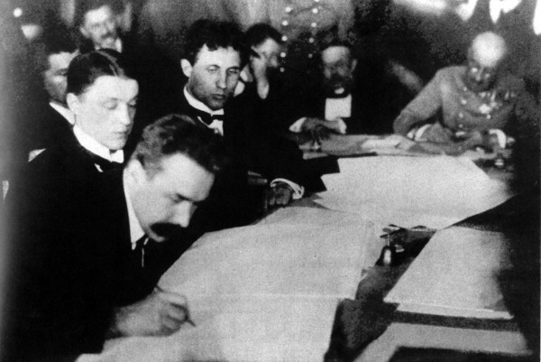 Image -- Mykola H. Levytsky signing documents at the Brest-Litovsk Peace negotiations (1918).