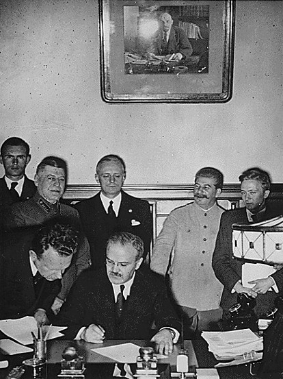 Image -- Viacheslav Molotov signs the German-Soviet non-aggression pact (Ribbentrop and Stalin in the background).