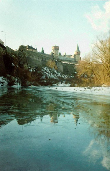 Image -- The Smotrych River flowing past the Kamianets-Podilskyi castle.